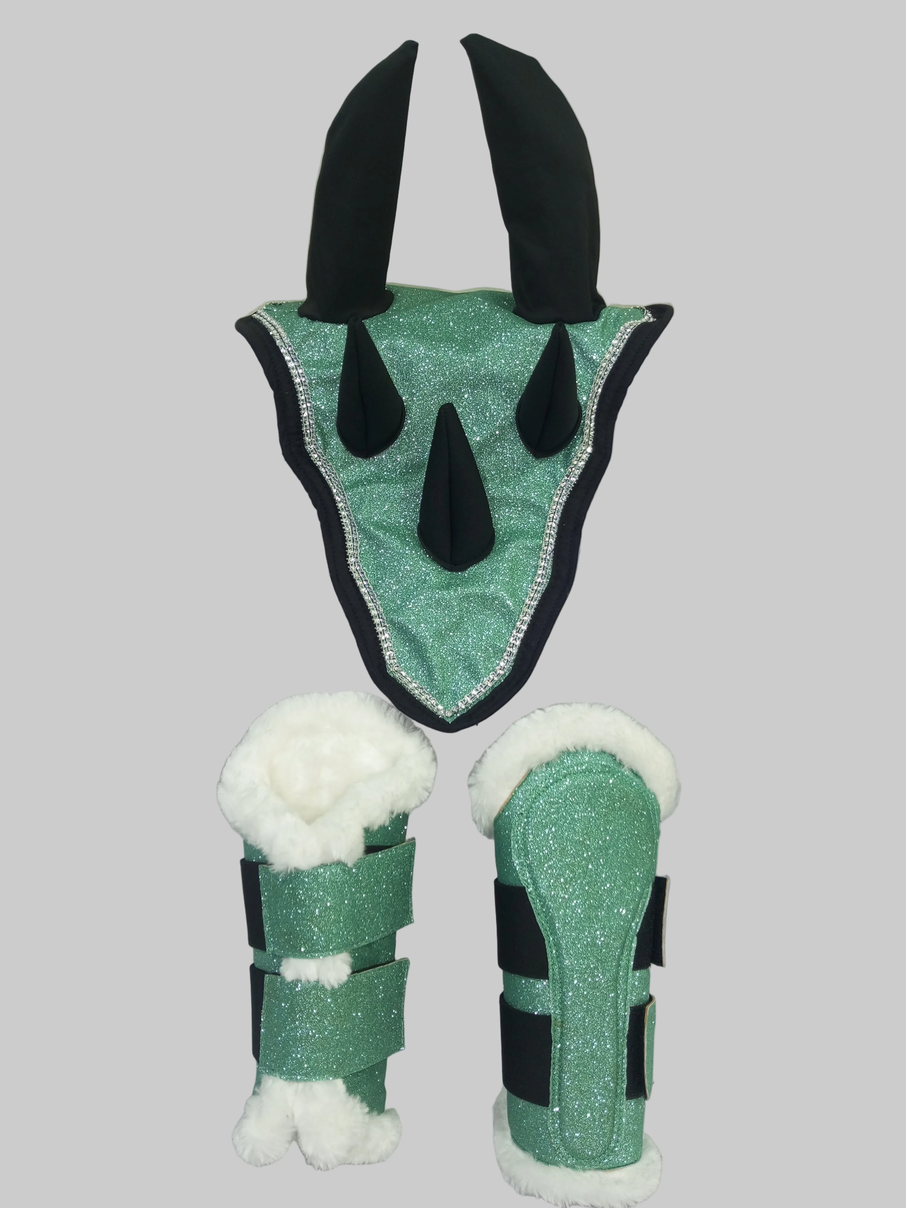 Green and black plush toy with white accents on a light gray background