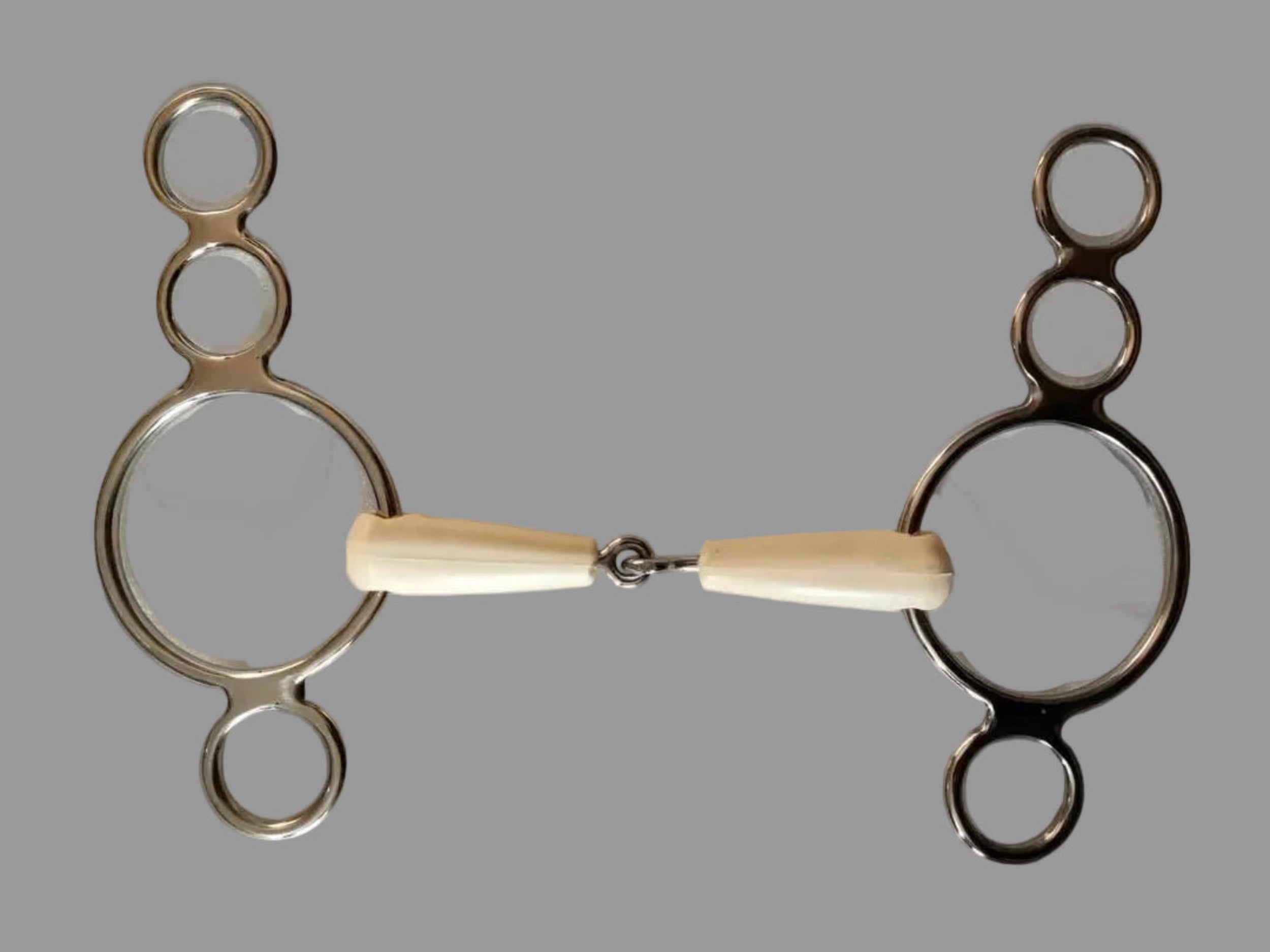 Metal horse bridle bit with bone handle on a gray background